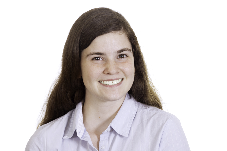 This Brian Charles Steel photo is a headshot of a white woman with long reddish hair, and a light blue dress shirt. She is centered in the frame, and the background is completely white.  She is lit with a slight Rembrandt style lighting. 